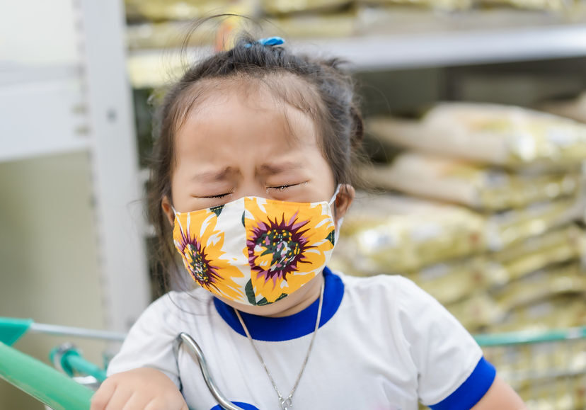 young girl upset while wearing mask