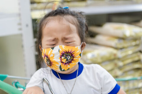 young girl upset while wearing mask