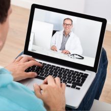 guy talking to doctor over computer webcam
